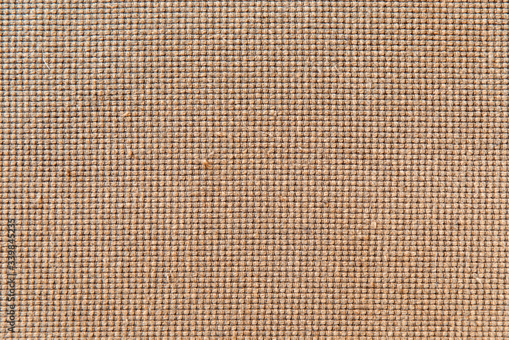 Close-up on the fabric covering an old sofa. The fabric is worn and has defects in some places. It is made of brown cotton, itself forming small balls at regular intervals Close-up on the fabric covering an old sofa. The fabric is worn and has defects in some places. It is made of brown cotton, itself forming small balls at regular intervals