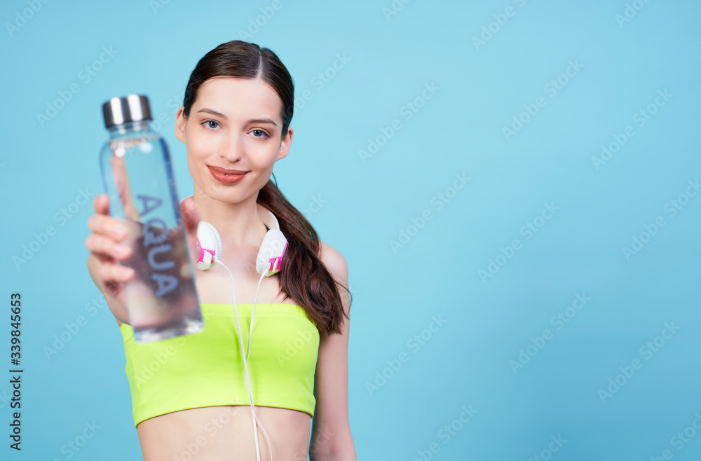 Young athletic girl in headphones with a bottle of water. Young athletic girl in headphones with a bottle of water.