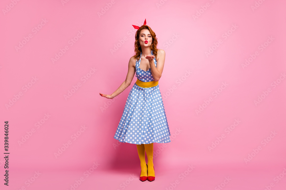 Full size photo of charming dreamy fancy girl send air kisses to rich wealthy guys wear red footwear polka-dot dress yellow pantyhose isolated over pink color background