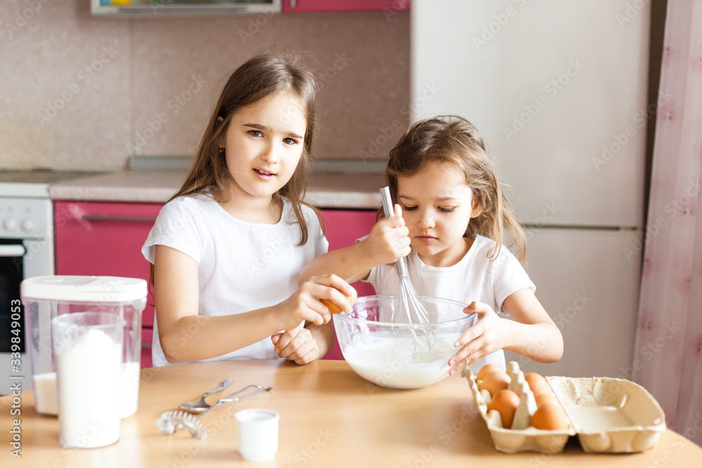 Sisters prepare Breakfast, pastries, mix flour, milk, eggs, pancakes in a bowl, children help mother, family Breakfast, cooking Sisters prepare Breakfast, pastries, mix flour, milk, eggs, pancakes in a bowl, children help mother, family Breakfast, cooking