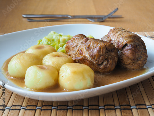 Silesian dumplings with pork roulade and cabbage in roast sauce