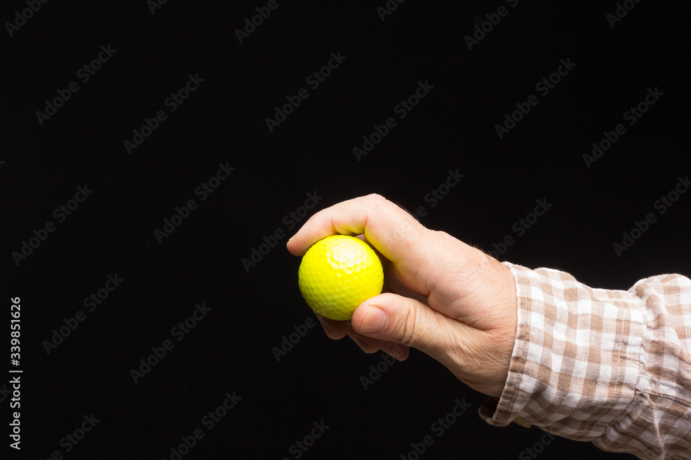 Golf ball in the hand of an adult person