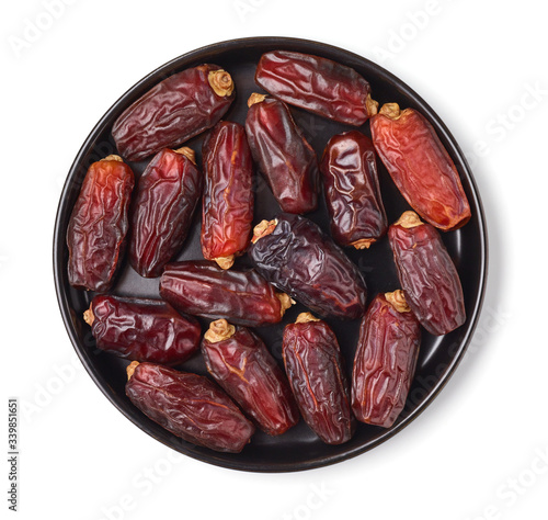 Dates on a black plate, isolated on white, from above photo