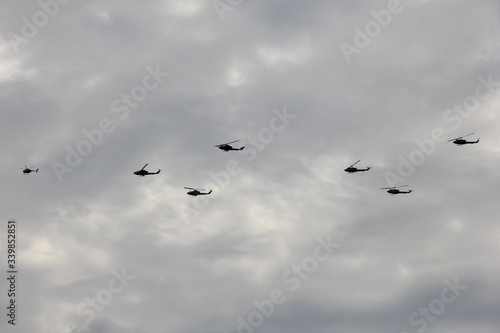 曇天に飛ぶ複数のヘリコプター