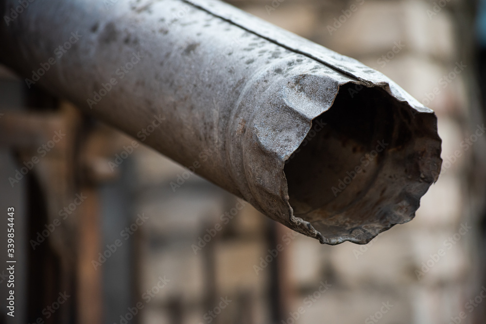 Old crumpled metal drainpipe is close Old crumpled metal drainpipe is close