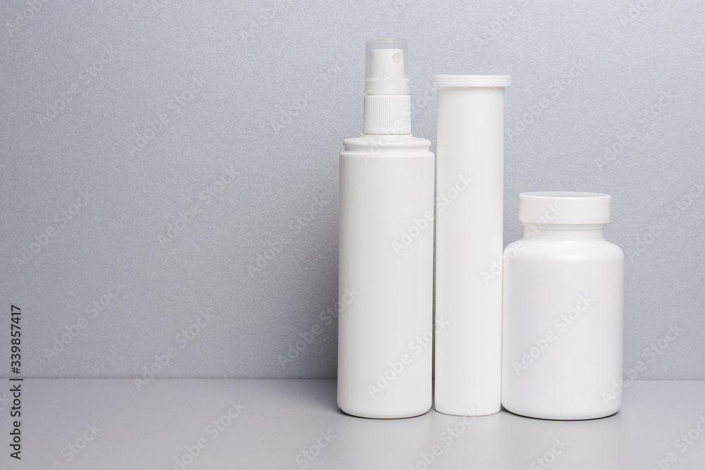 photo of three plastic cans for package pills and vitamins for protection against coronavirus KOVID-19 on a grey background. photo without bottle labels photo of three plastic cans for package pills and vitamins for protection against coronavirus KOVID-19 on a grey background. photo without bottle labels