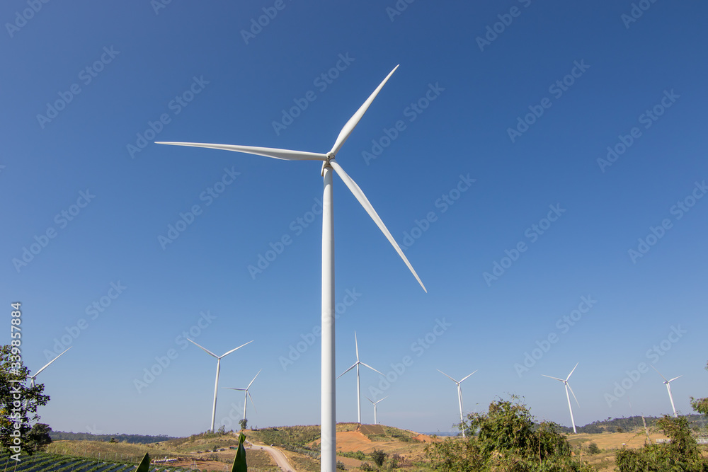 Beautiful green meadow with Wind turbines and sky  generating electricity in Thailand