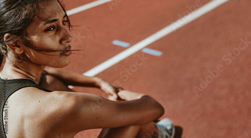 Fototapeta Naklejka Na Ścianę i Meble -  Fit woman after run sitting on race track
