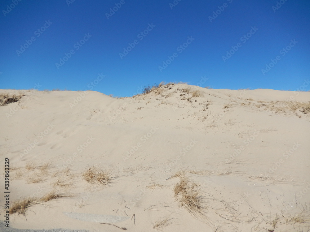 Large sand dune against a deep blue sky. No people, Copy space