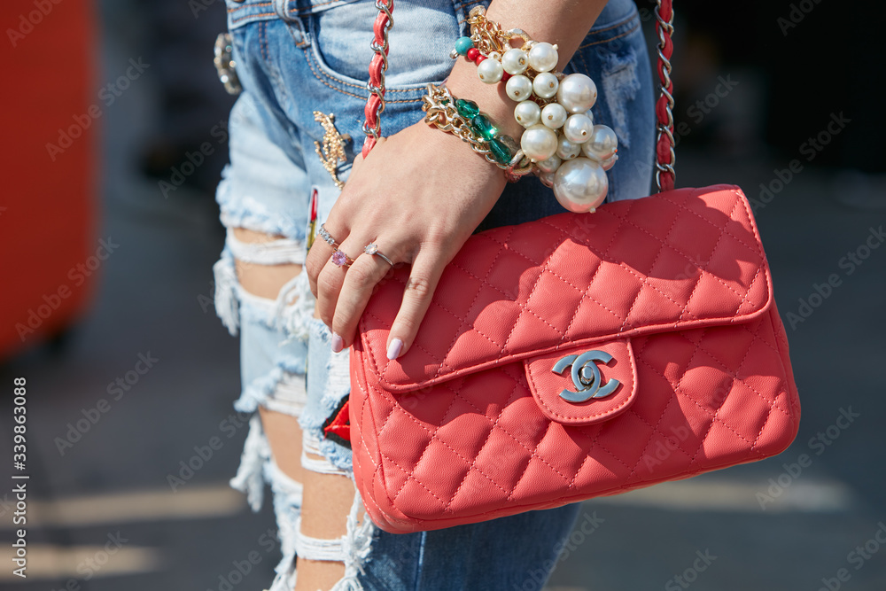 Woman with red Chanel bag and big pearls bracelet on September 25, 2016 in  Milan, Italy Stock Photo