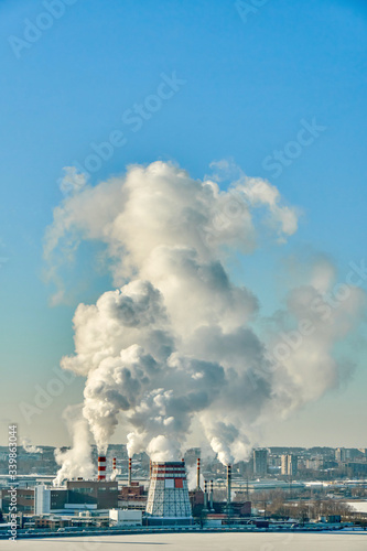 Thermal power station on a frosty day. Dense steam escaping from a thermal power plant