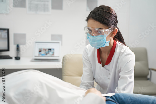 Concentrated young medical worker treating her patient