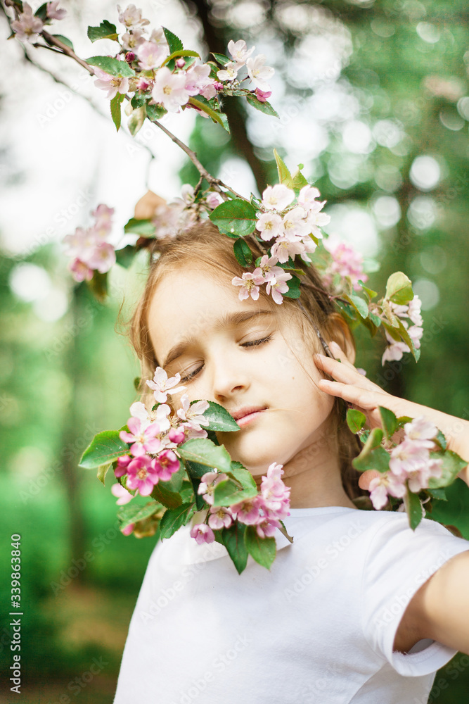 Girl spring branches of a flowering Apple tree, beauty and youth, portrait in flowering branches, trees, walk in the Park, rest