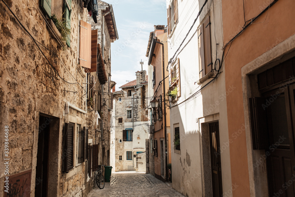 Travel summer concept. Old city view of Europe, Croatia, Istria region, Rovinj. Empty street with old buildings with shutters. Horizontal photo.