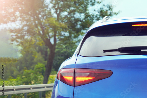 Led tail light of a blue car, luxury. A blue car behind a country road. Traffic outside the city.