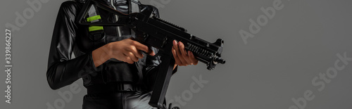 cropped view of futuristic african american woman with assault rifle isolated on grey