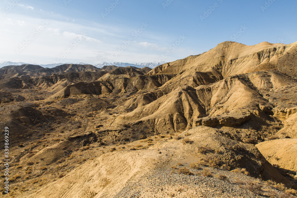 yellow sand hills in nature reserve in south coast of Issyk Kul with deep blue sky in Kyrgyzstan