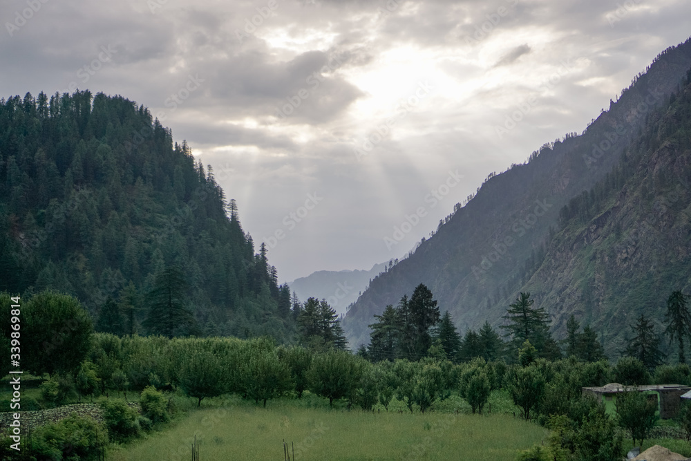 Fototapeta premium Sun Raise Coming Out from Clouds in Mountain Area