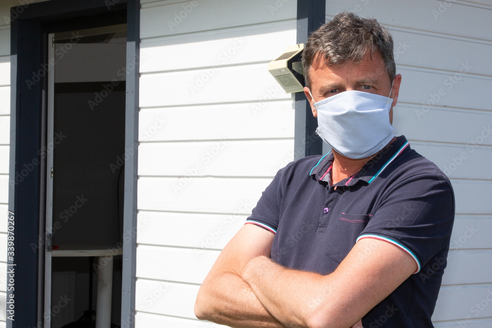 Man arms crossed wearing disposable fabric cotton homemade mask outdoors against coronavirus covid-19 dangerous virus Man arms crossed wearing disposable fabric cotton homemade mask outdoors against coronavirus covid-19 dangerous virus