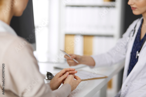 Doctor and patient discussing current health examination while sitting in clinic. Perfect medical service in hospital. Medicine concept © rogerphoto