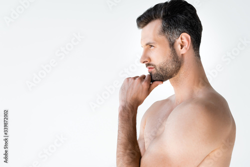 side view of shirtless man thinking and touching face isolated on white