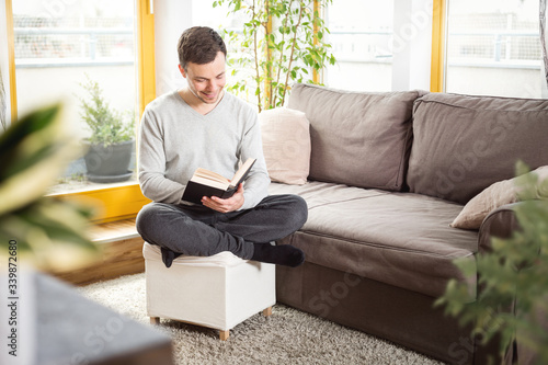 Man in his living room reading a book