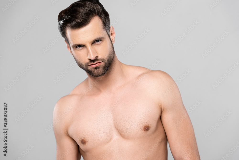 Fototapeta premium handsome and shirtless man looking at camera isolated on grey