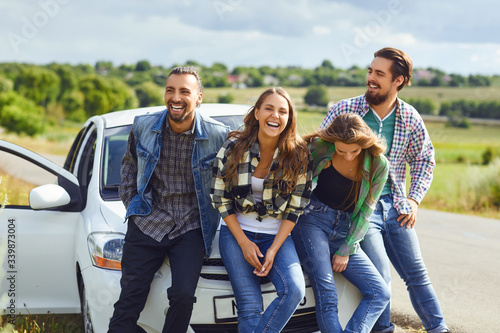 Group of people standing next travel in the car on road.