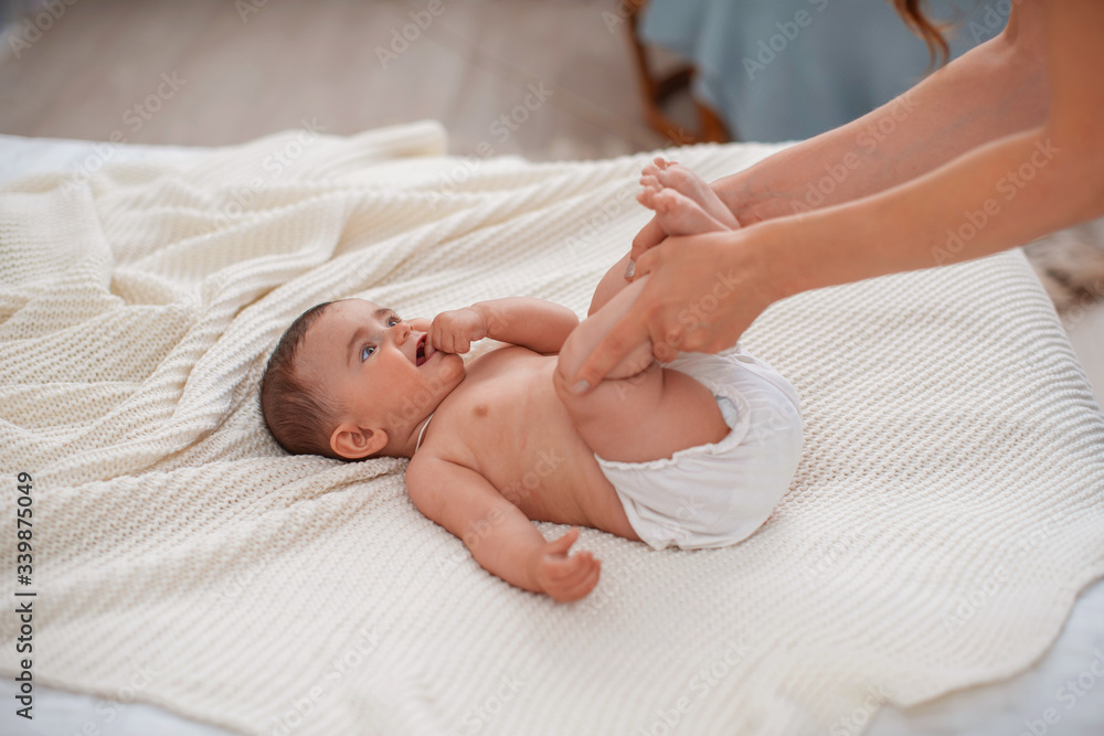 Baby massage. Woman does gymnastics for the baby for its development. Baby massage. Woman does gymnastics for the baby for its development.