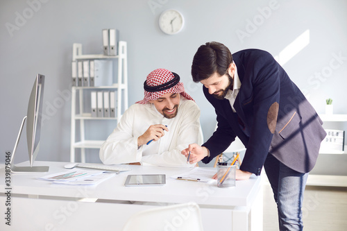 Schilderij op canvas Arab and european businessman working confident in a white office