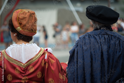 Persone con vestiti tradizionali  di spalle, del medioevo in una rievocazione medievale, Toscana,Italia photo