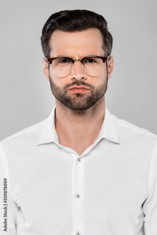 bearded man in glasses looking at camera isolated on grey bearded man in glasses looking at camera isolated on grey
