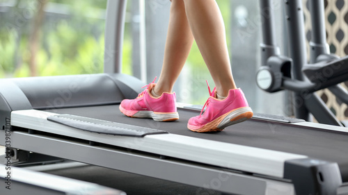young woman running on treadmill in gym