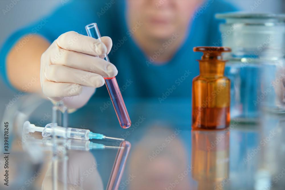 Fototapeta premium Scientist hand holding test tubes, laboratory research. viruses, coronavirus