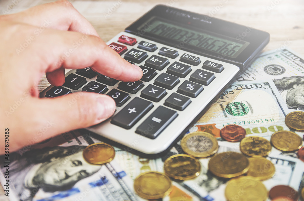 hand prints something on a calculator. Close-up. Revenue analysis, business development strategy. hand prints something on a calculator. Close-up. Revenue analysis, business development strategy.