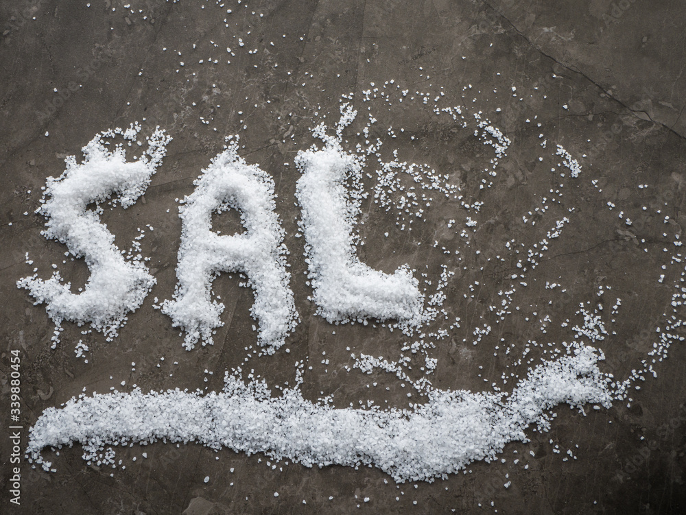 Spanish word SAL (SALT in English) written in salt grains spread on a