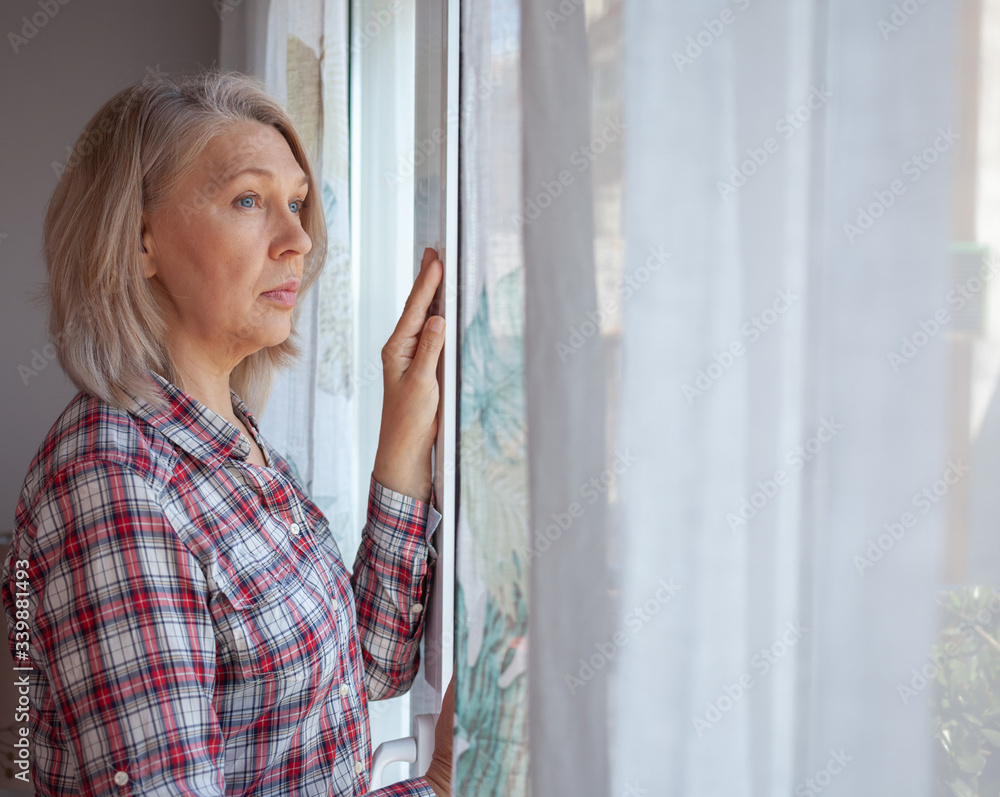 The woman in the room by the window. He looks sadly at the street. Quarantine. Loneliness. The woman in the room by the window. He looks sadly at the street. Quarantine. Loneliness.