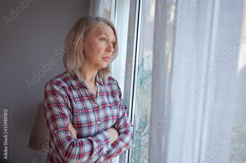 The woman in the room by the window. He looks sadly at the street. Quarantine. Loneliness.