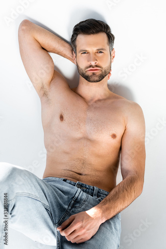 sexy and shirtless man in jeans on white