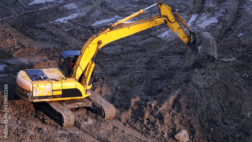 Tractors and excavators work on the construction of the foundation zero cycle
