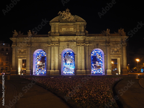 Puerta de Alcalá, monumento en el centro de Madrid, iluminado por la noche con luces de Navidad.