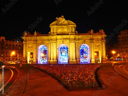 Puerta de Alcalá, monumento en el centro de Madrid, iluminado por la noche con luces de Navidad.