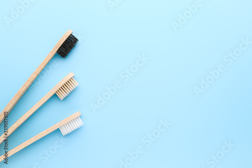 Zero waste and no plastic concept. Three eco friendly bamboo toothbrushes on a light blue surface. Top view  copy space  horizontal orientation. Layout natural organic hygiene products.
