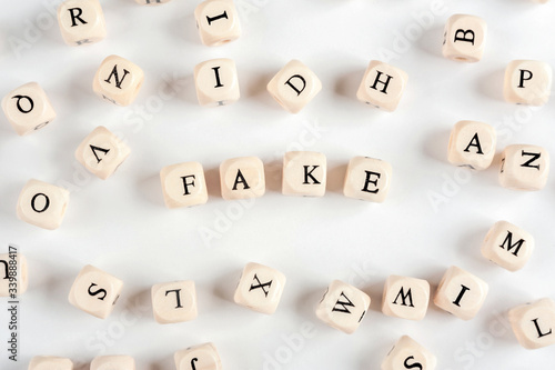 The word FAKE is made up of wooden blocks with letters. Background with letters..