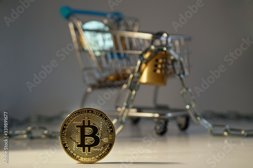 Bitcoingold with softfocus shopping cart with lock and safetychain, dark and ominous setting. Vertical and horizontal photo available. Also in lighter setting available. 2/2
 photo