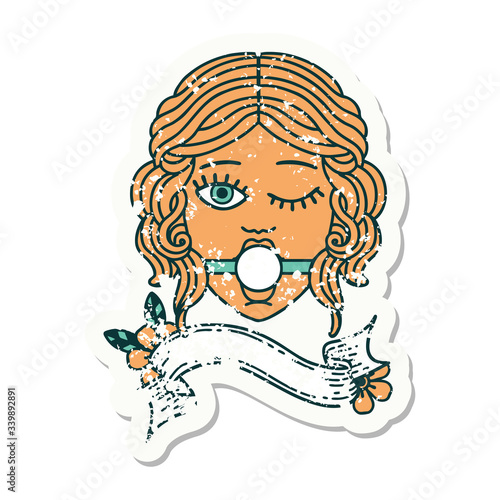 grunge sticker with banner of winking female face with ball gag