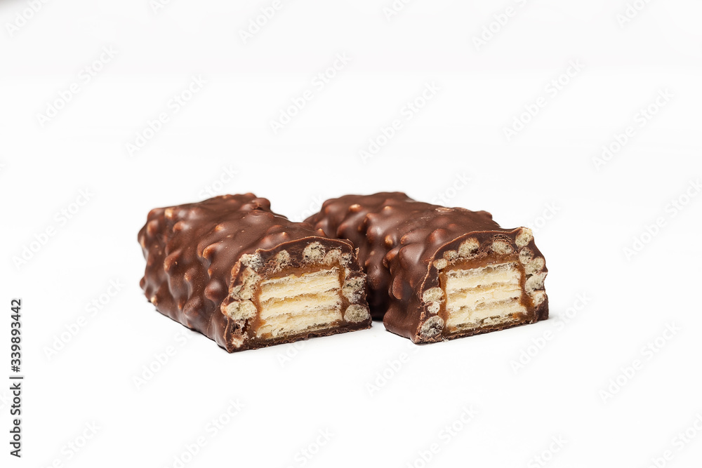 sliced chocolate bar with dark brown chocolate with nuts on a white background. sliced chocolate bar with dark brown chocolate with nuts on a white background.