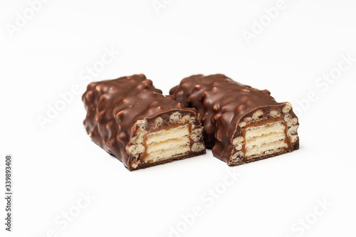 sliced chocolate bar with dark brown chocolate with nuts on a white background.