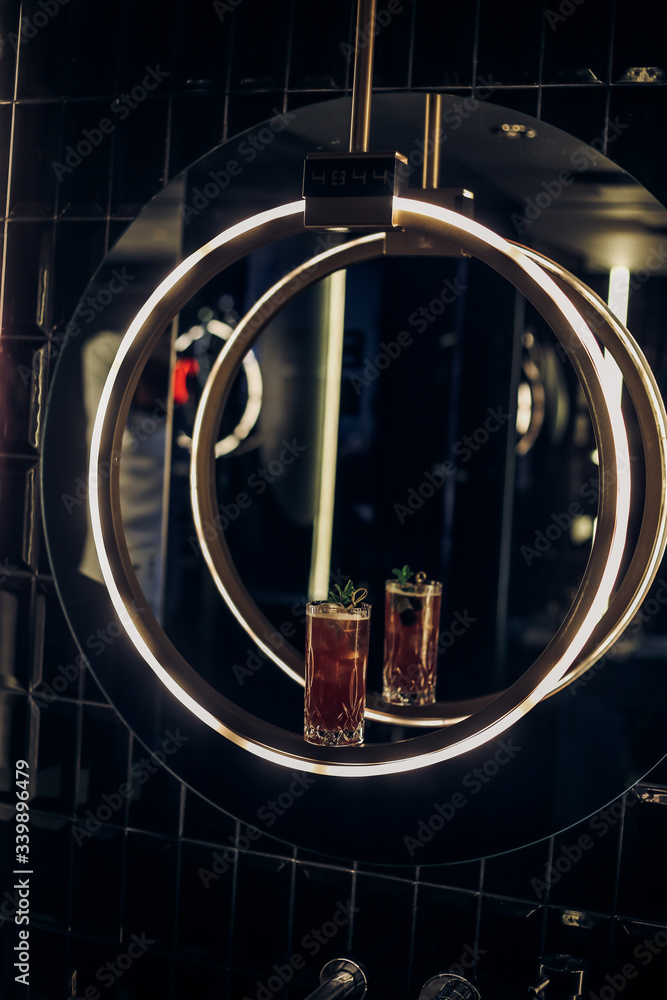 bright cocktail in a beautiful glass neon lighting and plants background 