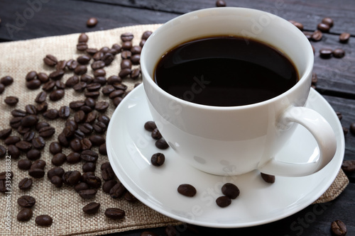 Black coffee, white glass on a wooden table, backdrop, coffee beans, top view